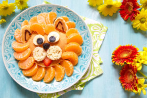 Funny lion pancake with mandarins and berries