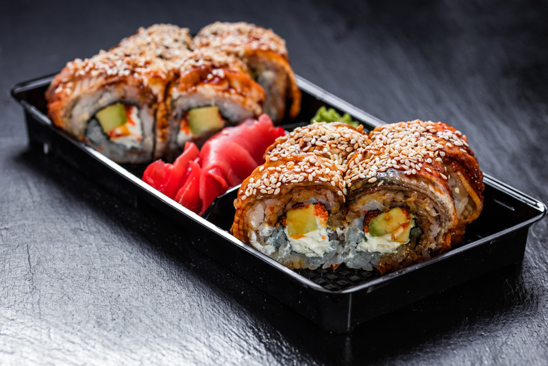 Unagi philadelphia makizushi american-style roll in a take-away delivery container