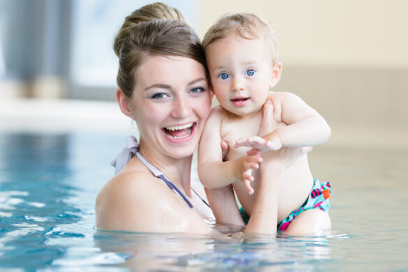 Mother and her newborn child at infant swimming class