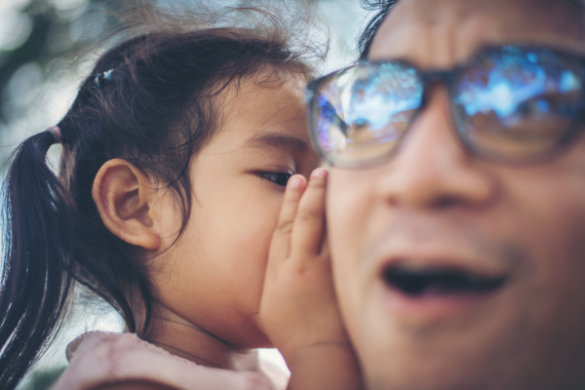 child whispering to dad