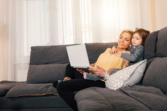 mum and child on lounge watching movie on laptop